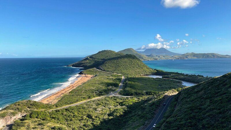 Karibische Schwestern Die Kleinen Antillen St. Kitts und Nevis Eine schmale bergige Landzunge zeigt von St. Kitts Richtung Süden zur Schwesterinsel – benannt nach dem höchsten Berg Schottlands, dem Ben Nevis. – Bild: SRF/​NDR/​nonfictionplanet/​Steffen Schneider