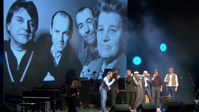 Peter Resetarits auf der Bühne mit seinen Brüdern Willi und Lukas. – Bild: ORF/​ORF III