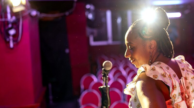 Jeniffer Morland war einst als „Schwarze Heidi „ auf der Comedy-Bühne bekannt. Doch der Tod ihres Stiefvaters brachte sie zum Schweigen. Heute führt sie drei Restaurants in Berlin. Jetzt will sie zurück auf die Bühne. Der Film begleitet Jeniffer hinter die Kulissen von Restaurants, Comedy Clubs und in die Schweizer Berge, wo für sie als Schwarzes Mädchen Idylle und Rassismus aufeinanderprallten. – Jeniffer Morland will zurück auf die Comedy-Bühne. – Bild: rbb/​VAYM Produktionen