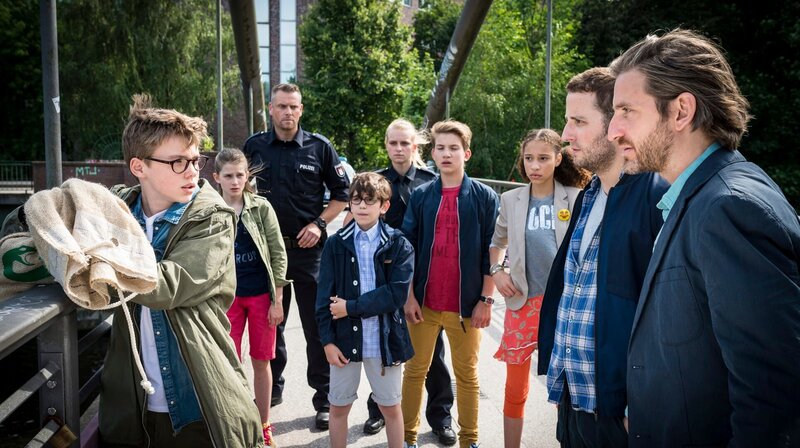 Schlangenliebhaber Gisbert (Tarik Sanli, Mitte) hofft, dass Benny (Ruben Storck) es schafft, seine Boa Constrictor vor den fiesen Drogenkurieren Roland (Bastian Reiber, 2. von rechts) und Sergio (Jonas Hien, ganz rechts) zu retten. – Bild: NDR/​Boris Laewen