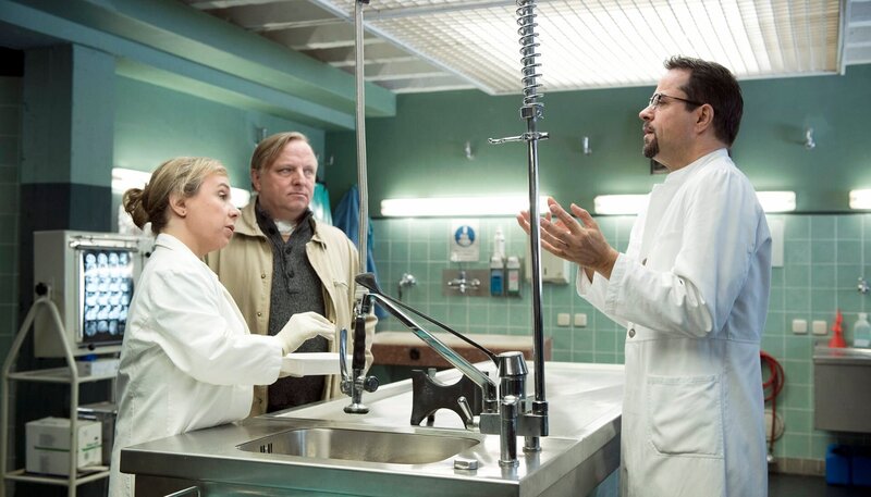 Silke Haller (ChrisTine Urspruch, l) hat eine Entdeckung gemacht: Prof. Boerne (Jan Josef Liefers, r) will sie persönlich Kommissar Thiel (Axel Prahl, M) erläutern. – Bild: WDR/​Martin Valentin Menke