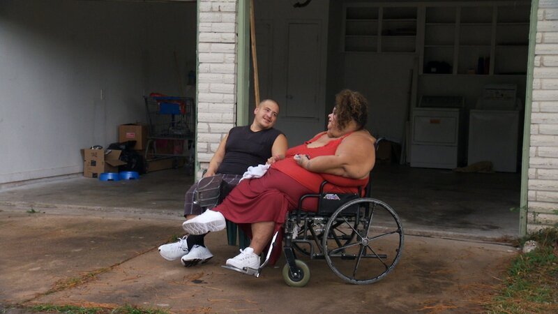 Lupe in a wheelchair with her husband Gilbert. – Bild: Discovery Communications