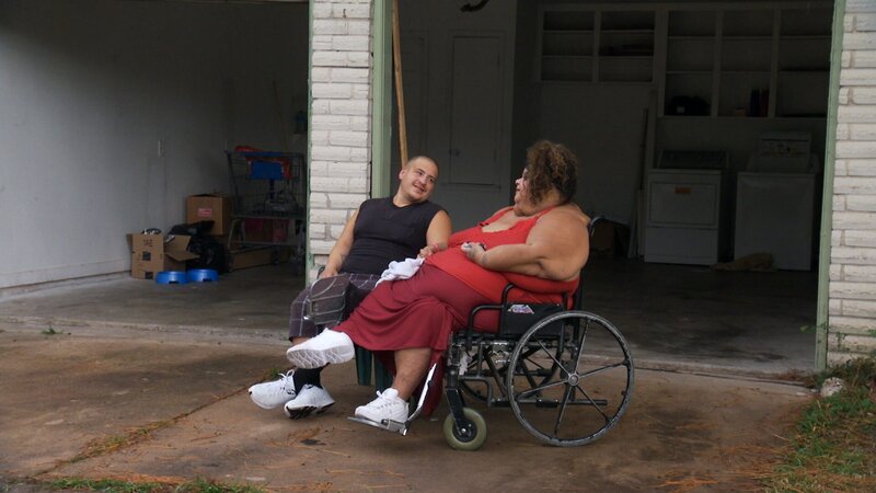 Lupe in a wheelchair with her husband Gilbert. – Bild: Discovery Communications