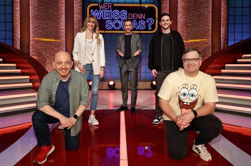 Moderator Kai Pflaume (M.) und seine Rateteam-Kapitäne Bernhard Hoëcker (l.) und Elton (r.) begrüßen in dieser Sendung die Moderatorin und Autorennfahrerin Eve Scheer (2.v.l.) und den Autorennfahrer und Influencer Daniel Abt (2.v.r.). – Bild: ARD/​Morris Mac Matzen