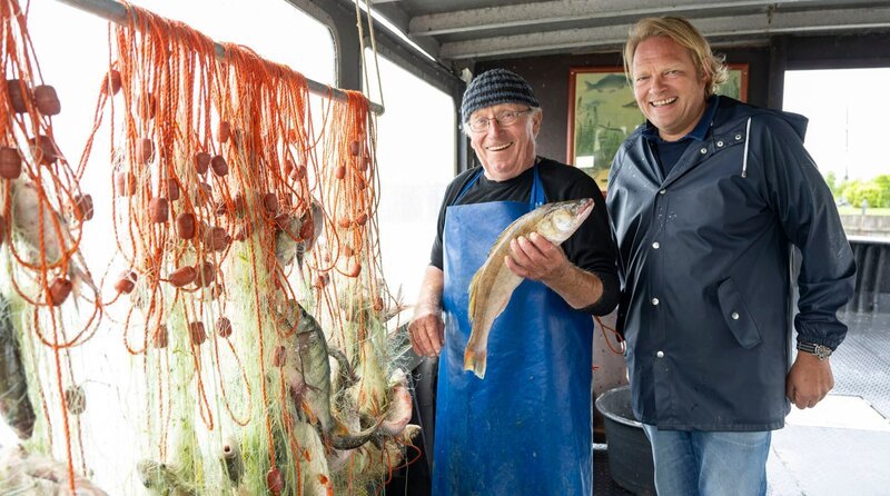 Björn Freitag (r) ist heute auf abenteuerlicher Mission auf dem Ijsselmeer unterwegs: In der Hafenstadt Hindeloopen trifft Björn Fischer Sipke Bootsma. – Bild: WDR/​Melanie Grande