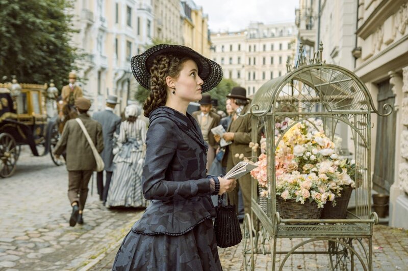 Sisi (Dominique Devenport) vor dem Wohnhaus der entlassenen Stallmeisterin Linda, deren Unterstützung sie für das Pferderennen gegen den Gestütsbesitzer Georg Basselet von La Rosée sucht. – Bild: ORF/​Beta Film/​RTL/​Story House Pictures/​Armands Virbulis