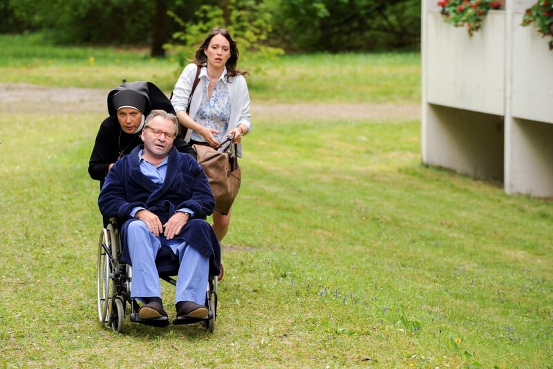 Schwester Hanna und Petra schaffen Wöller aus der Seniorenresidenz (v.li.: Janina Hartwig, Fritz Wepper, Nike Fuhrmann). – Bild: ORF/​Kineos/​ARD/​Barbara Bauriedl