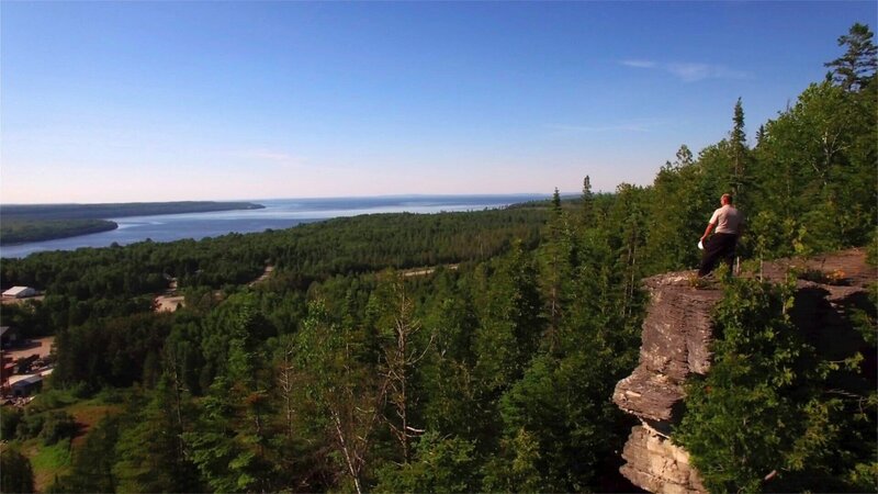 Traumrouten Amerikas Entlang der grossen Seen Grant Taibossigai am Bergabhang mit Blick auf Lake Huron – Bild: SRF/​Prounen Film