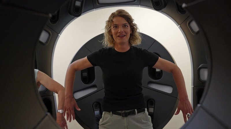 Reporterin Lena Ganschow stellt sich bei ihrer Suche nach Antworten auf die Frage „Wie viel Sonne ist gesund“ probeweise in einen hochmodernen Hautscanner, mit dem eine millimetergenau Hautanalyse möglich ist. – Bild: 3sat