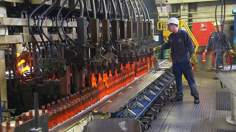 Pro Minute formt eine Maschine aus 1200-Grad-heißen Tropfen 400 Flaschen. Maschinenführer Christian Handelsmann kontrolliert die Formen aus Gusseisen. Sie werden einmal die Stunde gefettet, damit sich die warmen Flaschen gut lösen. Weitere Fotos erhalten Sie auf Anfrage. – Bild: NDR/​Kamera Zwei