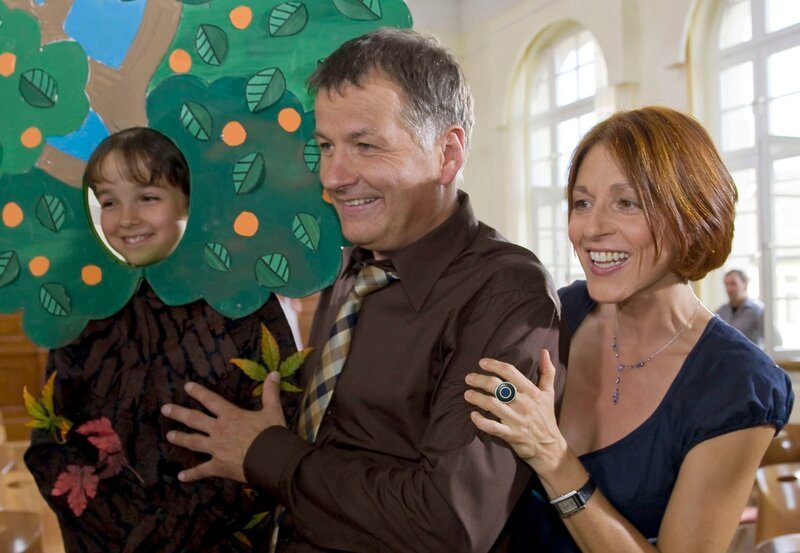 Das Schultheaterstück „Der Bär im Zauberwald“ wurde erfolgreich aufgeführt. Jonas Heilmann (Anthony Petrifke, links) hat einen Baum gespielt. Seine Eltern Dr. Roland Heilmann (Thomas Rühmann) und Pia Heilmann (Hedrikje Fitz) sind stolz. – Bild: MDR/​MDR/​Krajewsky