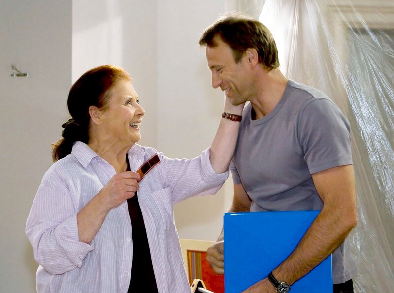 Martin (Bernhard Bettermann) kann Charlotte (Ursula Karusseit) aus der Patsche helfen. Er gibt ihr das Negativ vom Foto seiner Mutter und Charlotte kann es noch einmal vergrößern – so bemerkt Otto nichts von dem Missgeschick. – Bild: MDR/​Krajewsky