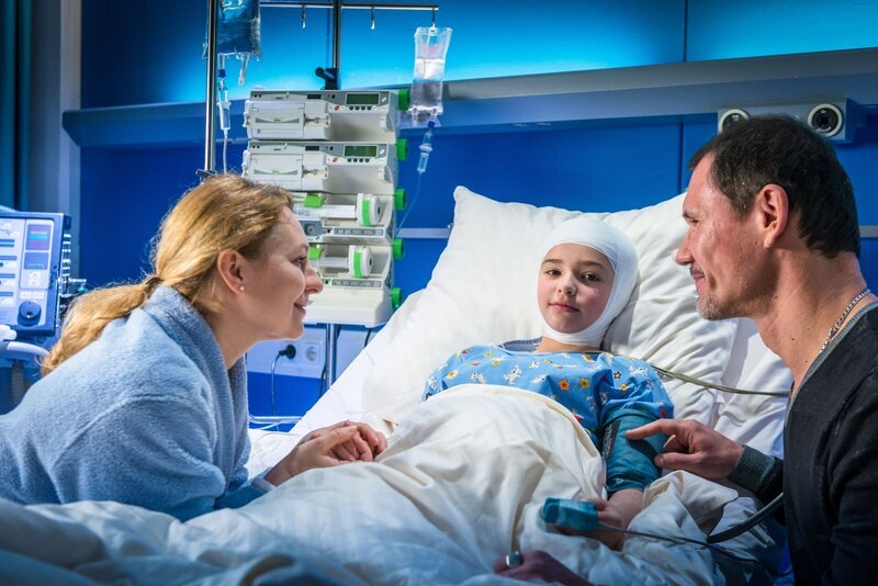 Irina (Jelena Knyaseva-Shmal, l.) und Vladimir (Dimitri Bilov) sind glücklich, dass ihre Tochter (Polina Shmal, M.) die OP überstanden hat. – Bild: ZDF