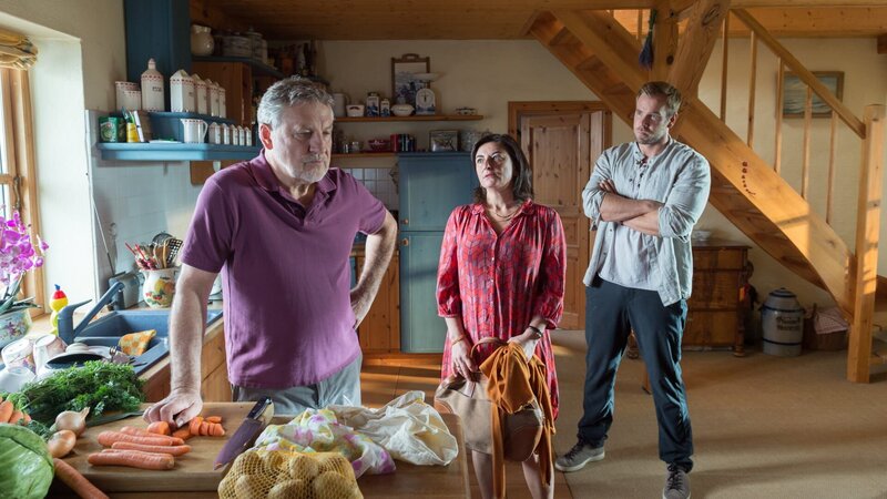 Während der Feier soll die Stimmung innerhalb der Band angeblich nicht gut gewesen sein. Nölitz’ Bandkollege Rainer Lemke (Andreas Rüdiger, l.) wiegelt hingegen gezielt ab: Alles sei in bester Ordnung. Dabei wirkt der Frührentner sichtlich nervös. Ist zwischen den beiden Männern ein Streit mit einem verhängnisvollen Ende entfacht? Pöhlmann (Dominic Boeer, r.) befragt Lemke und seine Frau Beate (Ilka Teichmüller). – Bild: ZDF und ZDF /​ Meyerbroeker