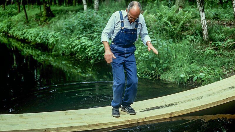 Peter Lustig (Peter Lustig) will eine Brücke über den Bach bauen – welche Konstruktion ist stabil und bringt ihn sicher ans andere Ufer? – Bild: ZDF