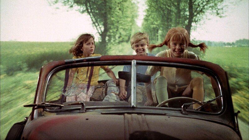 Pippi (Inger Nilsson, r.) hat das Autowrack, das ihr der Bauer geschenkt hat, wieder zum Laufen gebracht. Mit ihren Freunden Annika (Maria Persson, l.) und Tommy (Pär Sundberg, M.) setzt sie ihre Reise fort. – Bild: ZDF