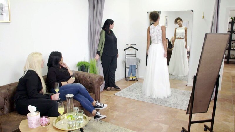 Kandidatin Laura (r.) probiert das erste Kleid an und ist gespannt auf die Reaktionen ihrer Freundinnen Kosica (l.) und Laura (M.). – Bild: RTL