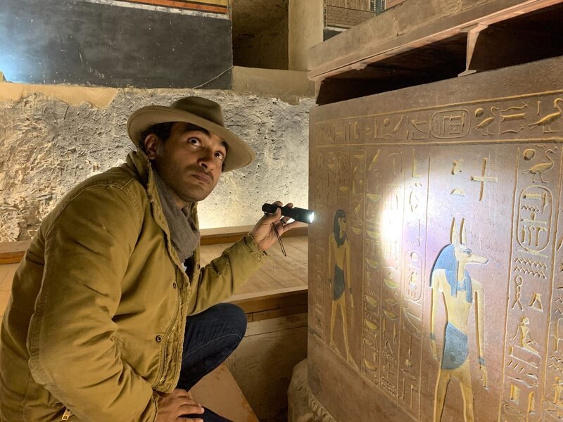 Ramy Romany looks at hieroglyphics with a flash light. – Bild: Discovery Communications LLC