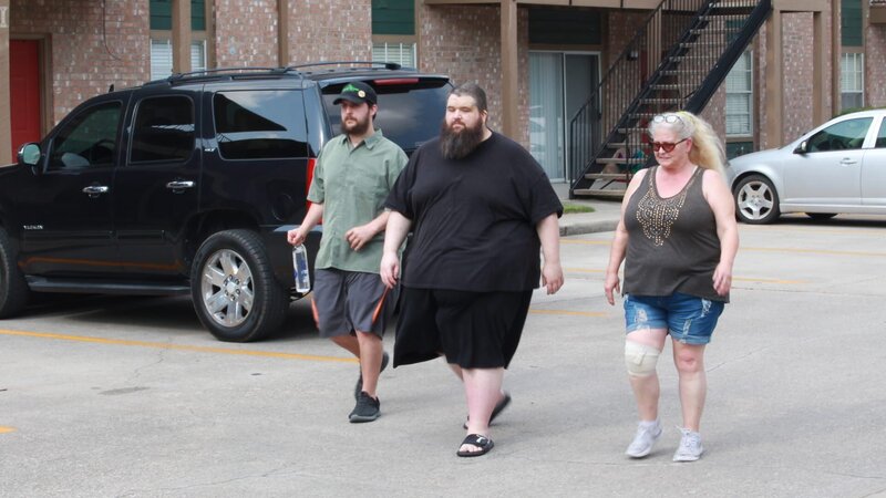 Chris (m.) walking with family outside apartment – Bild: Warner Bros. Discovery, Inc. or its subsidiaries and affiliates