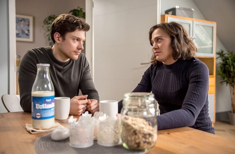 Am Morgen vor Rebeccas (Milena Straube, r.) Abreise sitzen Sie und Florian (Lion Wasczyk, l.) gemeinsam zu einem schnellen Frühstück zusammen. Aber: Wo führt das hin? – Bild: ARD/​Michael Kremer