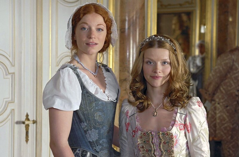 Prinzessin Paula (Karoline Schuch, rechts) und Frederike (Marleen Lohse, links) lassen den jungen Schneider David nicht mehr aus den Augen. – Bild: NDR/​Susanne Dittmann