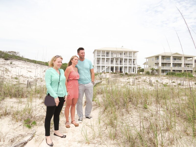Realtor, Anita Elisar (L) and the homebuyers, Greg Hartwick (R) and his wife, Gena (C) checking out the beach near the first home. – Bild: DMAX