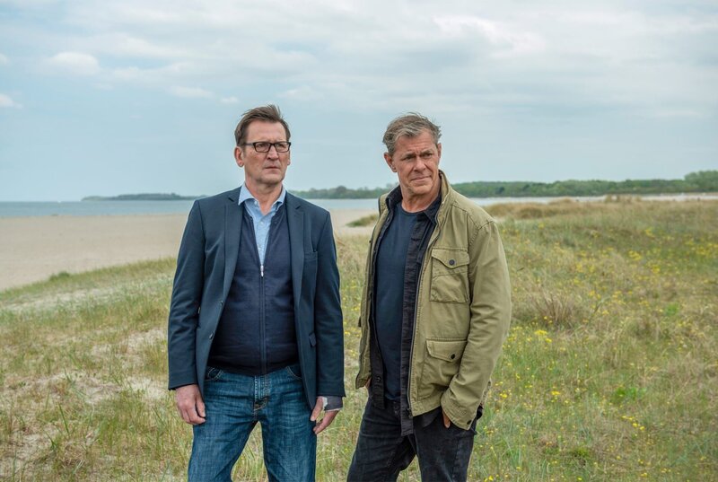 Ihr neuer Fall führt die Ermittler Lars Englen (Ingo Naujoks, li.) und Finn Kiesewetter (Sven Martinek, re.) an den Strand von Travemünde. – Bild: ORF/​ONE GATE/​ARD/​Thorsten Jander