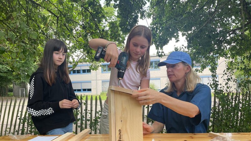 Antonia Coenen (r.) von den Berliner Spatzenrettern gibt in Workshops an Schulen praktische Tipps, wie der Lebensraum von Spatzen geschützt und erhalten werden kann. – Bild: ZDF