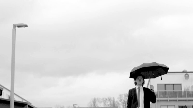 Anzug, Vorort, Reihenhaus: Jonas testet aus, ob in der Normalität nicht der eigentliche Wahnsinn steckt. – Bild: BR/​rbb/​weltrecorder