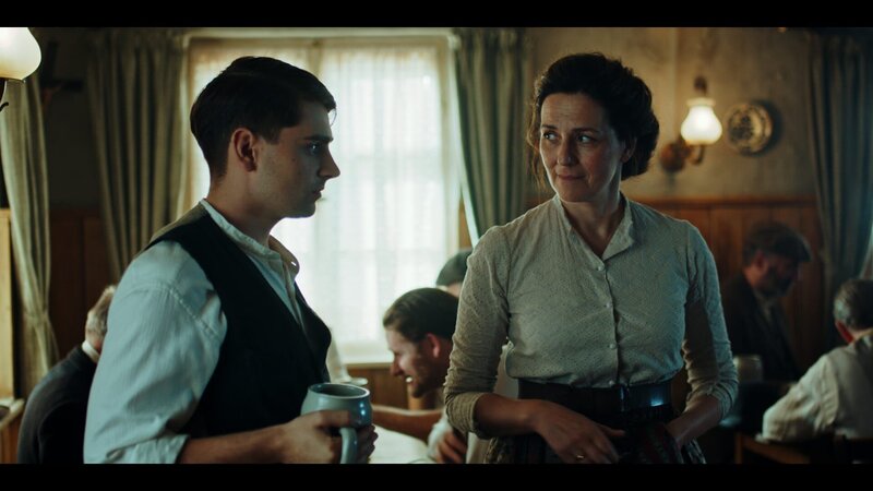 Maria Hoflinger (Martina Gedeck) tadelt im Wirtshaus „Zum Oiden Deibel“ ihren Sohn Ludwig (Markus Krojer), er soll keine Künstlerflausen im Kopf haben, sondern sich auf seine Zukunft als Wirt einstellen. – Bild: Felix Cramer /​ BR, ARD Degeto, MDR, WDR, Zeitsprung Pictures GmbH