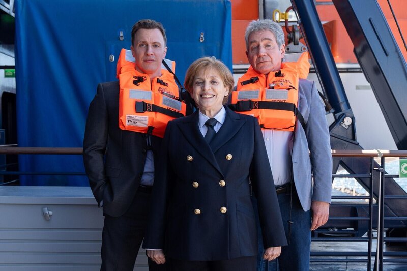 V.l.: Bodyguard Mike (Tim Kalkhof), Angela Merkel (Katharina Thalbach) und Joachim Sauer (Thorsten Merten) – Bild: RTL /​ Cristina Ríos Bordón