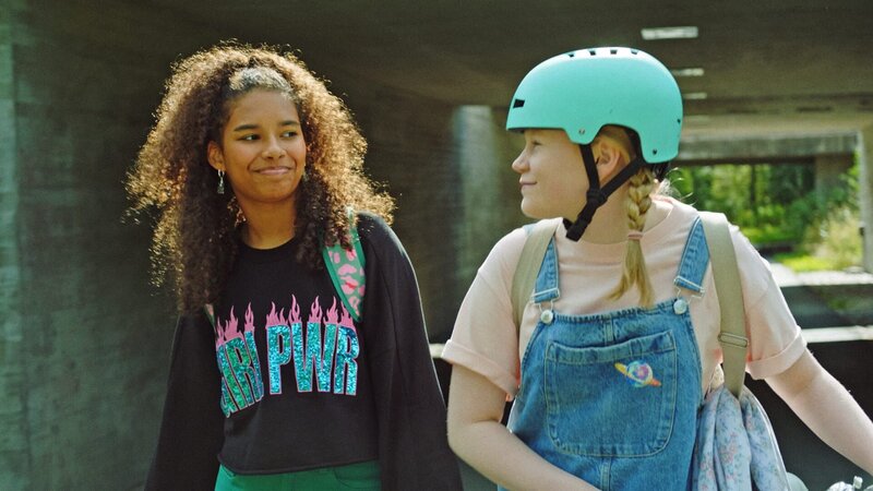 Ronya (Meilinn Dominguez) und Lumi (Mai Aalto) laufen nach einer Theaterprobe gemeinsam nach Hause. – Bild: KiKA/​Yle