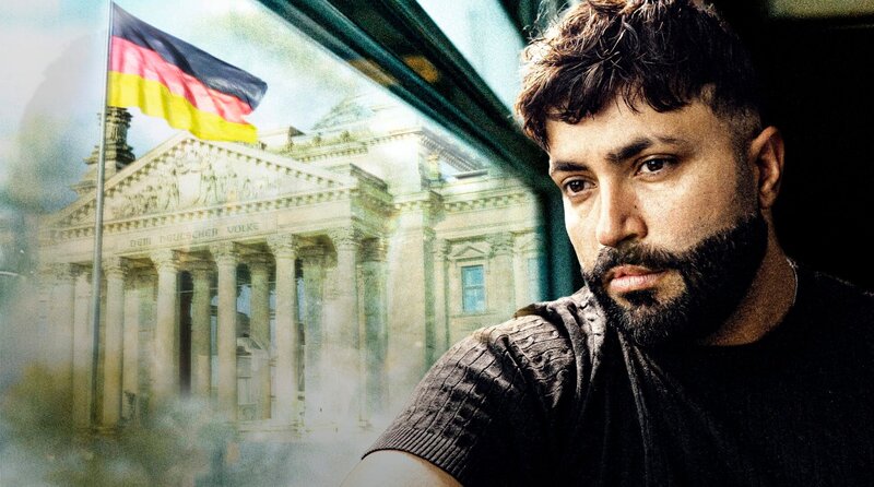 Sulaiman Tadmory blickt aus einem Zugfenster auf das Reichstagsgebäude in Berlin. – Bild: NDR/​Henning Wirtz picture alliance/​imageBROKER|Schoening