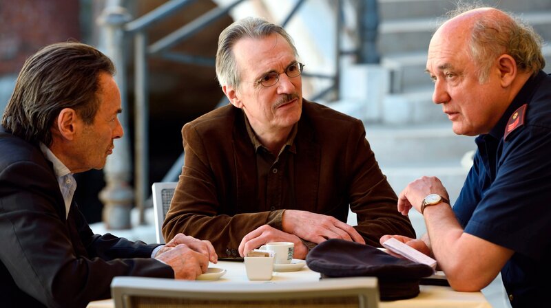 Kommissar Brunetti (Uwe Kockisch, li.) und Vianello (Karl Fischer, re.) vernehmen den Zeugen Dalla Lana (Stephan Bissmeier), dessen Freund ermordet wurde. – Bild: ORF/​ARD/​Nicolas Maack