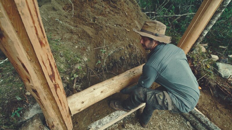 Matty stapelt Holzstämme und baut die ersten Wände einer neuen Blockhütte – Bild: National Geographic