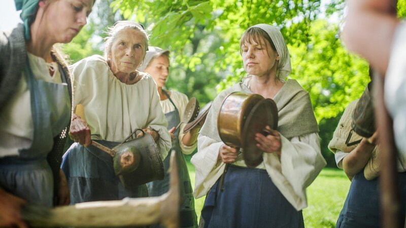 Vor der Praterschlacht sammeln sich die Frauen zu einem friedlichen Protestzug und verteilen Töpfe und Deckel, um Katzenmusik zu machen – eine laute Protestform, bei der Missstände durch Lärm angeprangert werden. – Bild: ORF/​Clever Contents