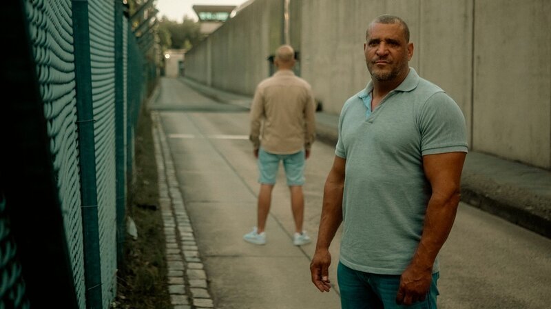  Marco kämpft, seit er denken kann. Zuerst mit Fäusten, jetzt mit Worten. Marco war Schwerverbrecher und saß in Haft. Nun hat er eine Ausbildung zum Life Coach gemacht und möchte anderen Ex-Häftlingen helfen, einen Weg zurück in die Gesellschaft zu finden. Er erlebt, wie schwer das ist. Aber er ist überzeugt: Jeder Mensch verdient eine zweite Chance. – Marco mit Coachee vor Gefängnis. – Bild: rbb/​Android Dreams Film /​ rbb Presse & Information