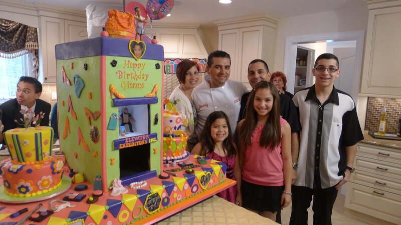 Buddy Valastro poses with family and elevator cake.A family poses with the elevator cake. – Bild: Discovery Communications, Inc.