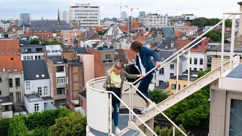 Nach einem gemütlichen Picknick auf einer Dachterasse in Antwerpen müssen Josefin (Sina Zadra) und Alexander (Frederik Götz) plötzlich über die Feuertreppe vor der Polizei flüchten. Die Verwendung des sendungsbezogenen Materials ist nur mit dem Hinweis und Verlinkung auf TVNOW gestattet. – Bild: Foto: RTL /​ Julia Feldhagen Die Verwendung des Materials der Mediengruppe RTL ist nur zur redaktionellen Berichterstattung im Zusammenhang mit der Sendung unter Angabe der Credits/​Quellenangabe und Beachtung der unter http:/​/​kommunikation.mediengruppe-rtl