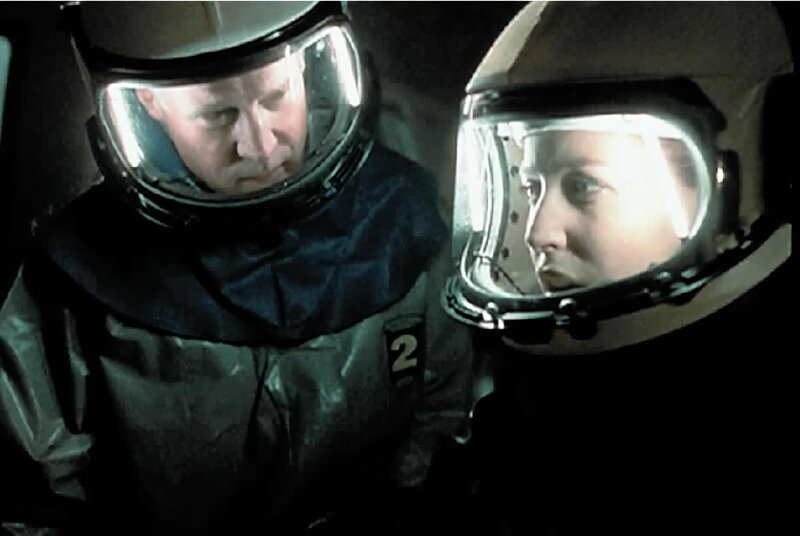 Scully (Gillian Anderson, r.) und ein Arzt vom Seuchenkommando kommen der Ursache für die mysteriösen Todesfälle auf die Spur. – Bild: SYFY