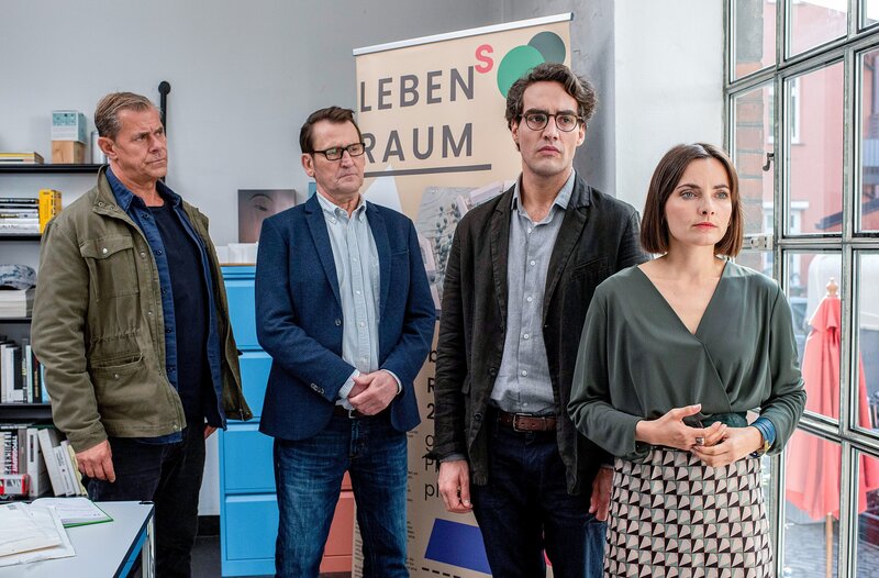 Die Kommissare Finn (Sven Martinek, l.) und Lars (Ingo Naujoks, 2.v.l.) überbringen Frank Eschenburg (Pascal Houdus, 2.v.r.) und dessen Ehefrau Ellen (Paula Schramm, r.) die Nachricht vom tödlichen Anschlag auf Franks Zwillingsbruder Jan. – Bild: ORF/​ONE GATE/​ARD/​Thorsten Jander