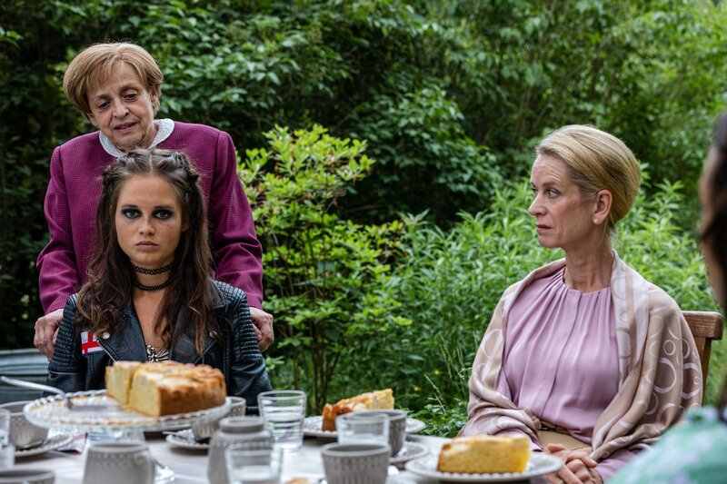 Miss Merkel (Katharina Thalbach, l.) löst den Mordfall, während ihre geladenen Gäste Katharina von Baugenwitz (Judith Engel, r.), Pia von Baugenwitz (Bianca Nawrath, M.) ihr aufmerksam zuhören. – Bild: RTL /​ Maor Waisburd