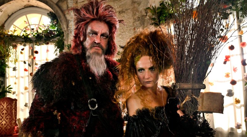 Trostlos und armselig ist die Welt geworden. Die Menschen haben keine Zeit mehr füreinander. Das spüren auch Rose und Heinrich, deren Eltern vor lauter Arbeit keine Zeit für ihre Kinder bleibt, um ihnen zum Beispiel Geschichten vorzulesen. Eines Tages entdecken die Geschwister auf einem Haufen Unrat ein altes Märchenbuch und ein Abenteuer beginnt. – Teufel (Detlev Buck) und Hexe (Christina Große) müssen die Kinder auf dem gefährlichen Weg zum Haus der Liebegüte begleiten. – Bild: rbb/​Hardy Spitz