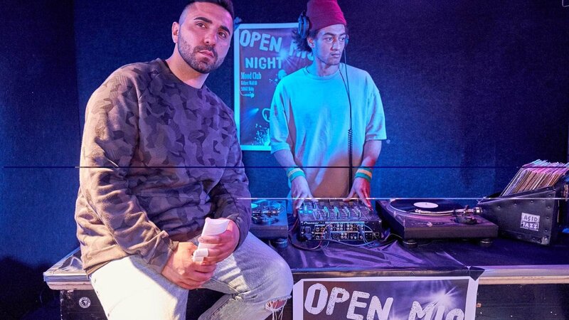 Der Rapper Mo Trip (l.) kündigt bei der „Open Mic night“ den Auftritt von Günni an. – Bild: TVNOW /​ Frank Dicks