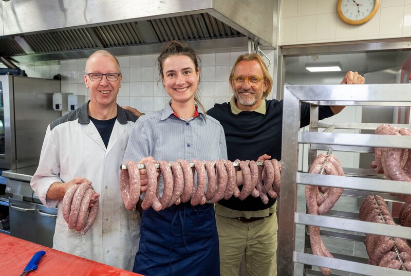 Frank Buchholz (re.) mit Metzgerin Josja Haagsma (mi.) und Gerk Biesma (li.). Josia Haagsma, Europameisterin der Jungmetzger, ist nach ihrer Ausbildung in den Traditionsbetrieb ihres Meisters eingestiegen und führt ihn mit großem Ideenreichtum und Knowhow in die Moderne. – Bild: WDR/​Melanie Grande