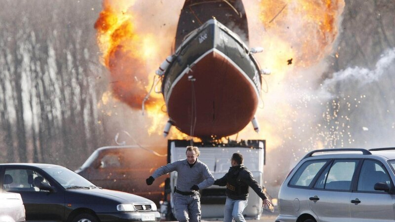 Bei der Explosion fliegt ein Boot durch die Luft: Semir (Erdogan Atalay, r.) und Gabor Fischer (Wilfried Hochholdinger) laufen um ihr Leben. – Bild: MG RTL D /​ Guido Engels