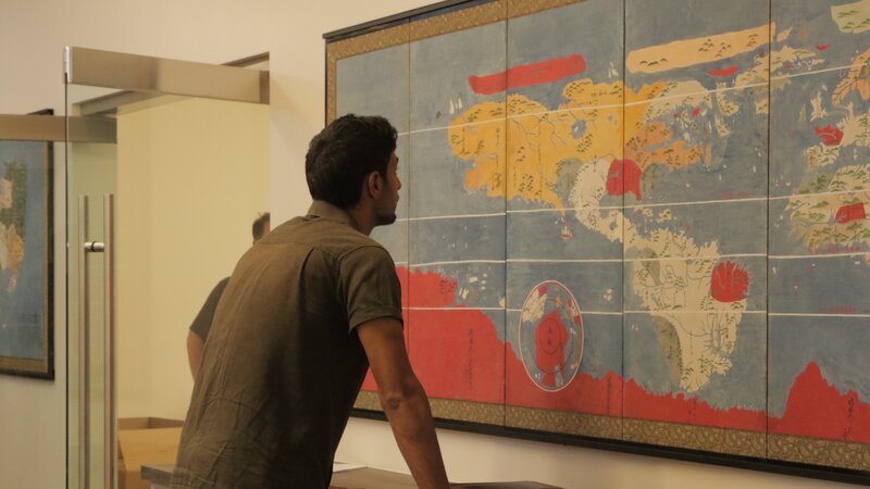Emiliano Ruprah studies a map at Barry Lawrence Ruderman Antique Maps Inc. – Bild: Discovery Communications, LLC
