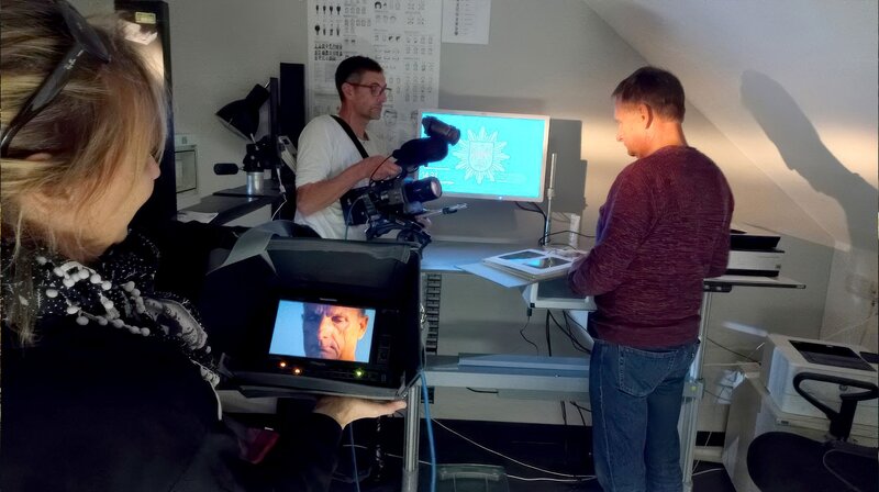 Der Kriminaltechniker Jens Bülow (re.) erklärt, bei den Dreharbeiten, die Ergebnisse der Spurensuche. – Bild: rbb/​Dokfilm