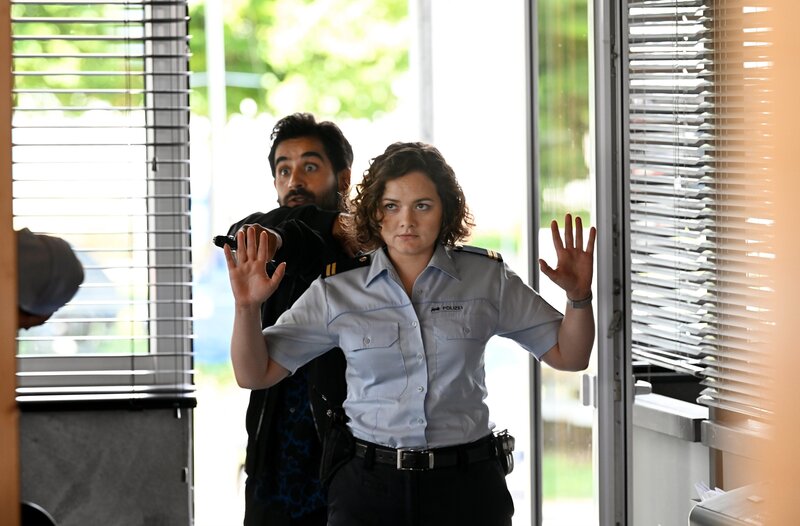 Julia Demmler (Wendy Güntensperger, v), wird von Geiselnehmer Victor (Tanju Bilir, h.) bedroht. – Bild: ARD/​Laurent Trümper