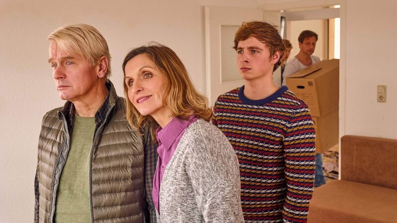 Stefan Vollmer (Hendrik Duryn, hinten) hindert Ole (Matti Schmidt-Schaller, r.) daran, seinem Vater Bernd Wenk (Horst Kotterba, l.) die Wahrheit über den Job in der Schule zu sagen. (Mitte Eva Manschott als Beate Wenk) – Bild: TVNOW /​ Frank Dicks